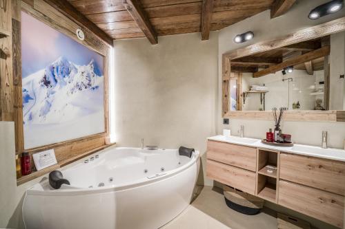 a bathroom with a tub and a sink and a mirror at Pleta del Tarter Lodge & SPA in El Tarter