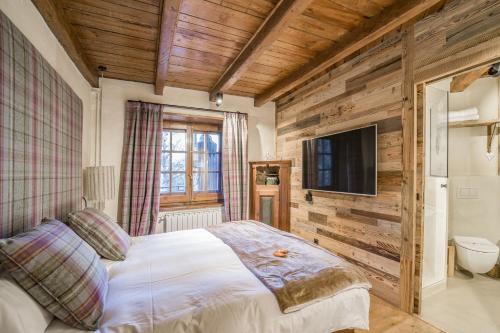 a bedroom with a bed and a flat screen tv at Pleta del Tarter Lodge & SPA in El Tarter