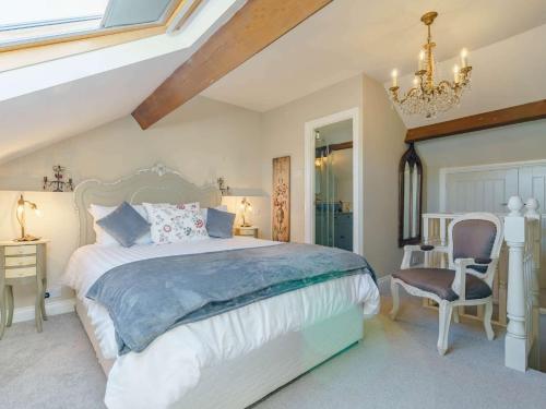 a bedroom with a large bed and a chandelier at 3 Bed in Amble 83995 in Amble