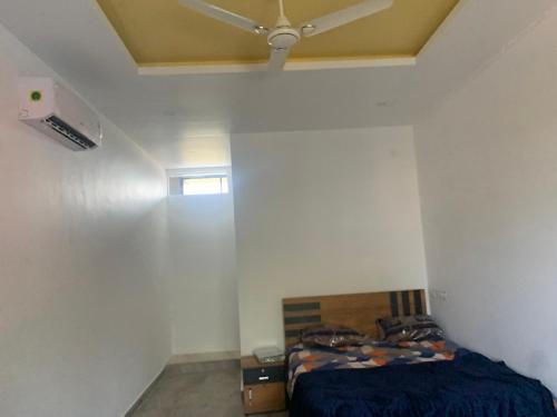 een slaapkamer met een bed en een plafondventilator bij S N M ROOM in Malappuram