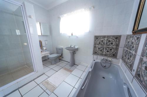a bathroom with a tub and a toilet and a sink at Graceland Self-Catering Cottages in Winterton