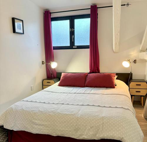 una camera da letto con un grande letto con tende rosse di GITE DANINOU; meublé 3 chambres avec terrasse (1er étage du château) , salon et cuisine ouverte a Vouvray