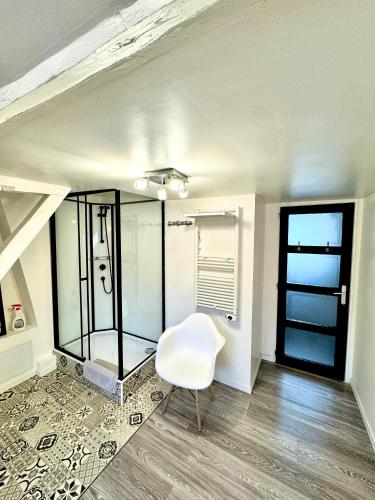 une chaise blanche dans une chambre avec fenêtre dans l'établissement GITE DANINOU; meublé 3 chambres avec terrasse (1er étage du château) , salon et cuisine ouverte, à Vouvray