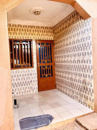 a room with two doors and a tiled wall at Résidence meublée in Ouagadougou