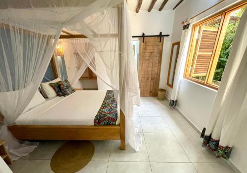 a bedroom with a bed with mosquito nets at Nakupenda paje villa in Paje