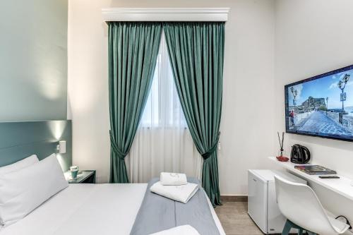Schlafzimmer mit einem Bett, einem Schreibtisch und einem TV in der Unterkunft Rafilina's House in Neapel