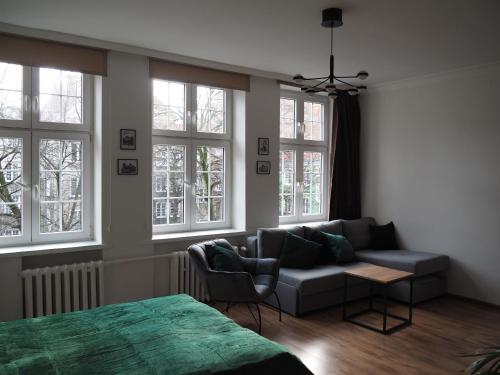 ein Wohnzimmer mit einem Sofa und Fenstern in der Unterkunft Grand-Tourist Old Town Center Apartments in Danzig