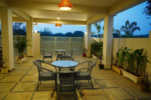 a patio with tables and chairs on a porch at Hotel Urban Sleep Airport Zone in Shamshabad