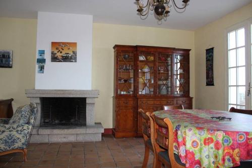 une salle à manger avec une table et une cheminée dans l'établissement 702 - Maison face à la plage au Domaine De Lanruen, à Le Val