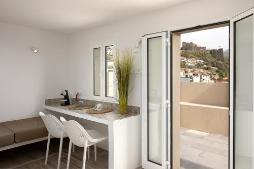 a bathroom with a counter with chairs and a sink at Luna Rossa by Homie in Funchal