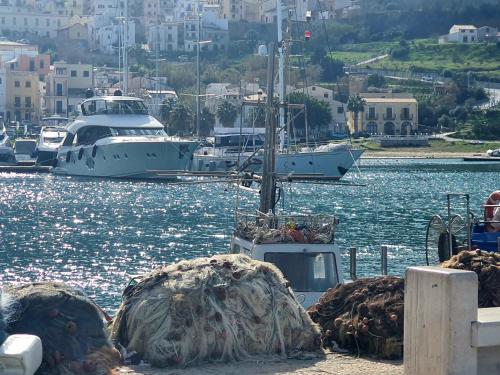 a group of boats are docked in the water at Hotel Cala Marina in Castellammare del Golfo