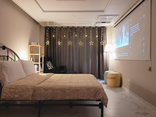 a bedroom with a bed and a large screen at Relax-편안한영화관,130인치대형스크린,넷플,디즈니플러스,넓은객실,장기숙박추천 in Namyangju