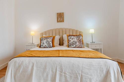 a bedroom with a large bed with two tables at Home near Évora's main square with private terrace in Évora