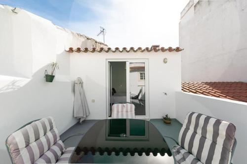 a room with two chairs and a table and a mirror at Home near Évora's main square with private terrace in Évora