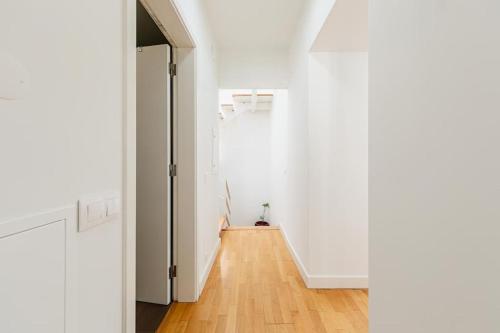 a hallway with white walls and a wooden floor at Home near Évora's main square with private terrace in Évora