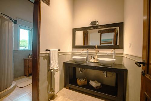 a bathroom with two sinks and a mirror at Eunoia casa de campo in Sinsacate