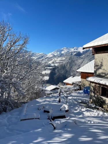 a snow covered yard with a mountain in the background at LE MOULIN DE NAVETTE - La Meule in Aigueblanche