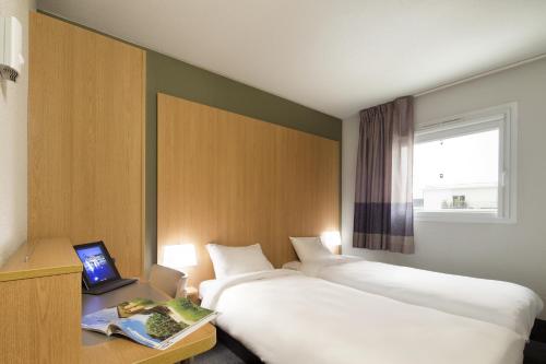 Un pat sau paturi într-o cameră la B&B HOTEL Perpignan Sud Marché International