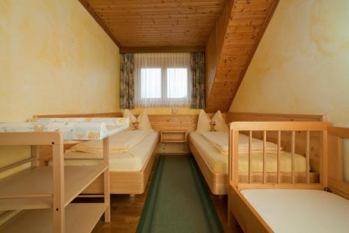 Zimmer mit 2 Etagenbetten und einem Fenster in der Unterkunft Gourmetbauernhof Mentebauer in Gmünd in Kärnten