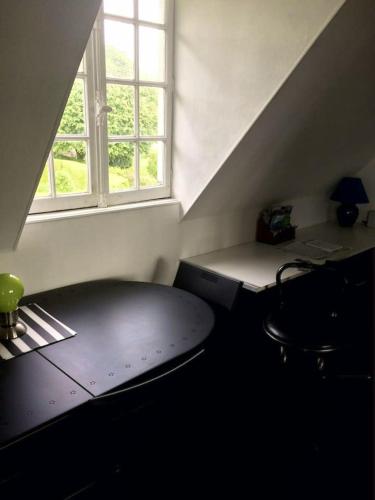 Cette chambre dispose d'une table, d'un bureau et d'une fenêtre. dans l'établissement Appartement charmant à Hautot-sur-Mer, 45 m² avec stationnement, à Hautot-sur-Mer