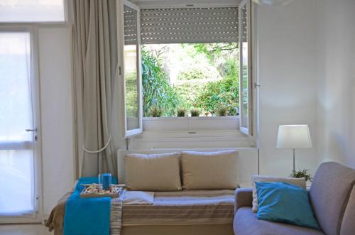 a living room with a couch and a large window at Appartamento Emozione Mare Blu San Terenzo in Lerici