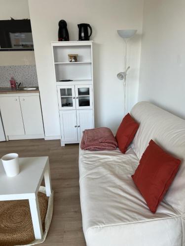 um sofá branco com almofadas vermelhas numa sala de estar em Le Central - Studio avec terrasse Camas,Timone em Marselha