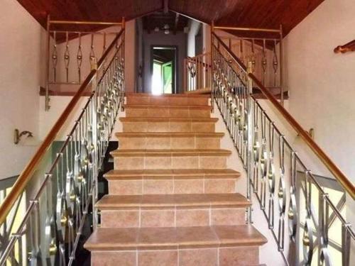 a staircase with wooden railings in a building at Balatoni Panoráma Villa in Balatonalmádi