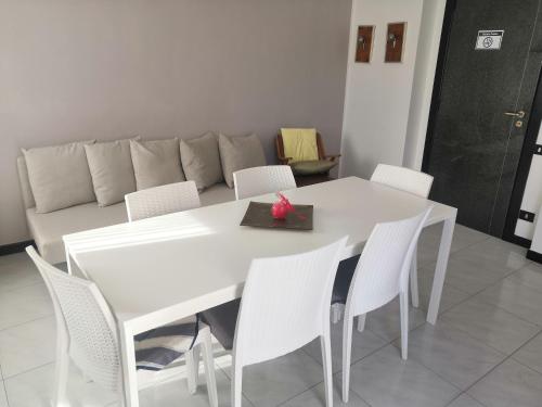 mesa de comedor blanca con sillas blancas y sofá en Casa vacanza Parco del Castello, en Matera