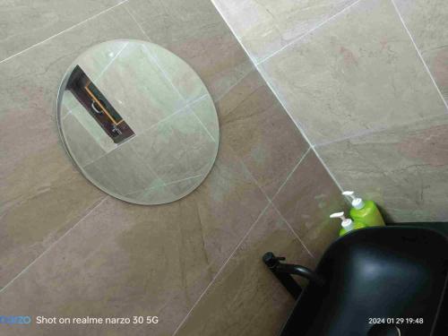 espejo redondo en el suelo de un baño en The King's Castle en Guwahati