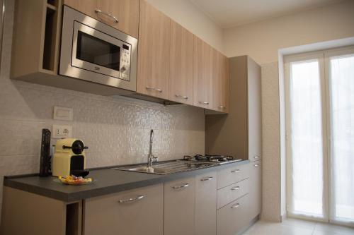 a kitchen with a sink and a microwave at Maison Noel in Cava deʼ Tirreni
