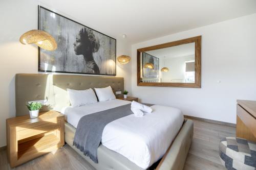a bedroom with a large bed and a mirror at A l'aube de Bali in Amnéville