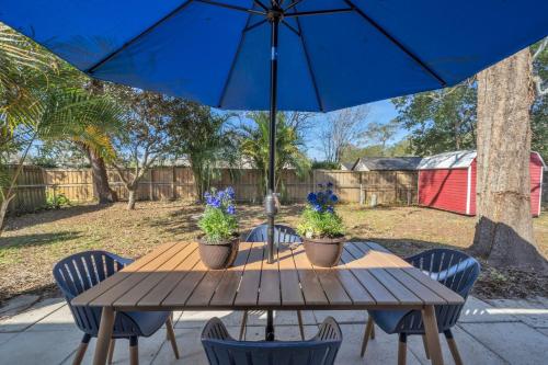 a wooden table with chairs and a blue umbrella at Serenity Retreat- Charming Home Near Attractions! home in Brandon