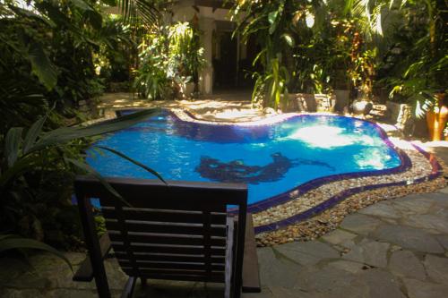 una piscina en un patio con una silla al lado en Villa Olde Ceylon, en Kandy
