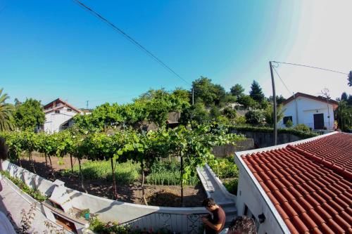 a woman standing on top of a house with a garden at Casa Dos Cabecinhos in Paradamonte