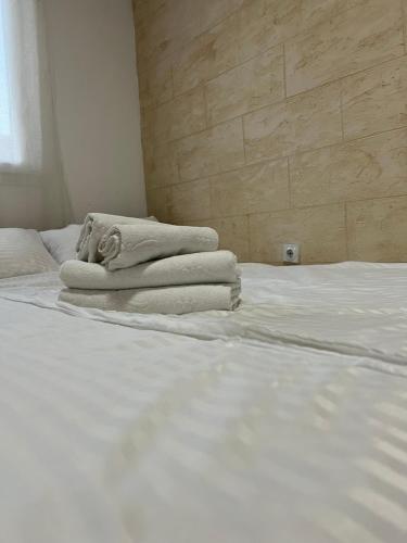 a bed with white sheets and towels on it at Holiday Lux Apartment in Soko Banja