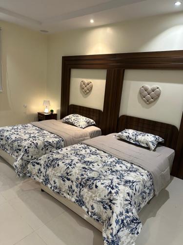 2 camas en un dormitorio con corazones en la pared en شقة مفروشة غرفتين بدخول ذاتي en Al Kharj