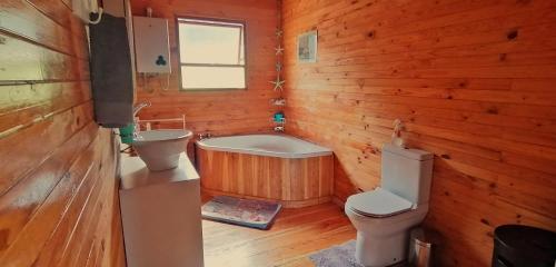 a bathroom with a toilet and a tub and a sink at Summer Villa in Mossel Bay