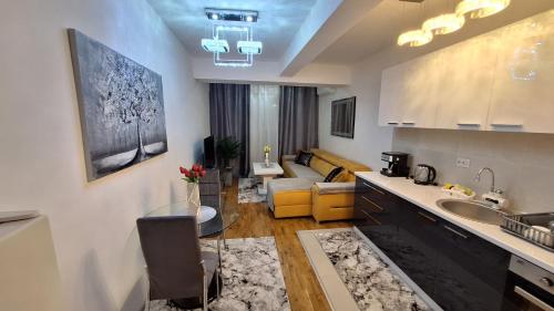 uma cozinha com um lavatório e uma sala de estar em Luxury Apartment Santorini em Skopje