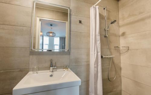 a bathroom with a sink and a shower with a mirror at Hotel Orion in Rotterdam