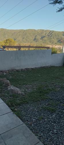a wall in a yard with a field of grass at Casa de montaña in Bialet Massé