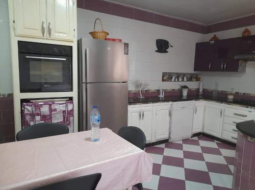 eine Küche mit einem Tisch und einer Flasche Wasser darauf in der Unterkunft Appartement à Oran in Oran
