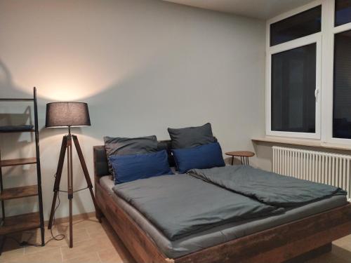 a bedroom with a bed with blue pillows and a lamp at Andris Apartments in Stuttgart