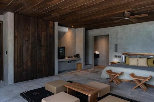 a bedroom with a bed and a wooden ceiling at Umi Tulum in Tulum