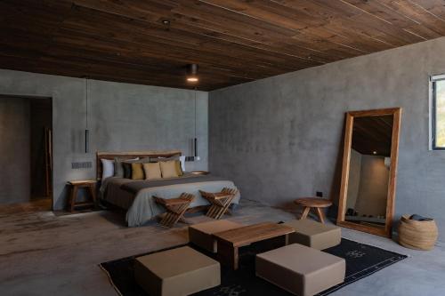 a bedroom with a bed and a wooden ceiling at UMi Tulum in Tulum