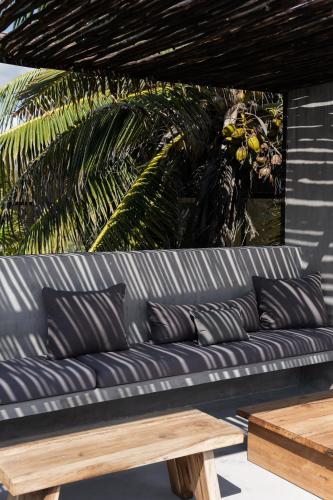 a blue couch with pillows and a wooden table at UMi Tulum in Tulum
