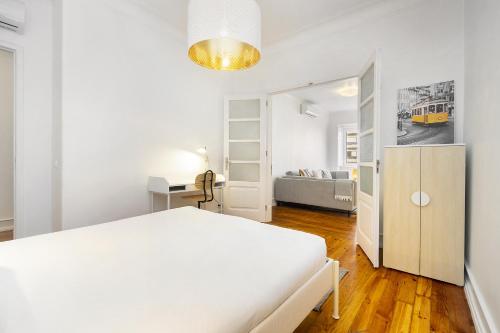 Biała sypialnia z białym łóżkiem i biurkiem w obiekcie WHome Mid-Term Marvel: Your Home Away from Home w Lizbonie