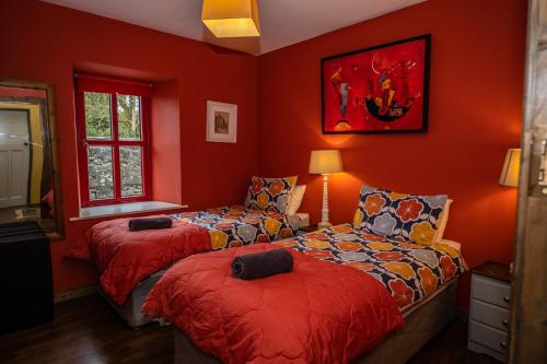 a red room with two beds and a couch at Marianne Cottage in Ráistín