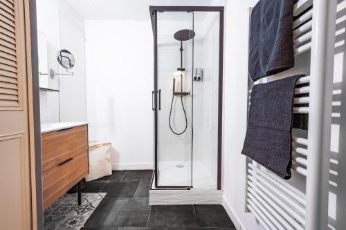 a bathroom with a shower with a glass door at CŒUR DU VENTOUX Carpentras Bel appart 6 places in Carpentras