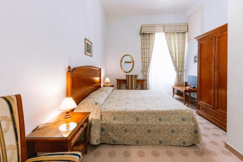 a bedroom with a bed and a dresser and a table at Hotel Toro in Ravello