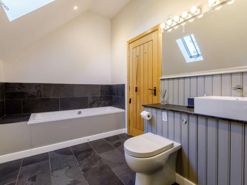 a bathroom with a toilet and a tub and a sink at 3 Bed in Ashreigney 65742 in Ashreigney